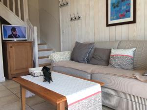 a living room with a couch and a coffee table at la baie des voiles ,vue lac d'Annecy ,plage privée in Duingt