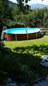 a person swimming in a pool in a yard at Ferienwohnung Villa Heinrich in Feld am See
