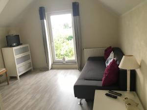 a living room with a bed and a window at Ferienhaus Am Park Leipzig in Leipzig