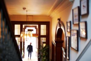 a man walking down a hallway in a building at The Roseate Edinburgh - Small Luxury Hotels of the World in Edinburgh +85 photos