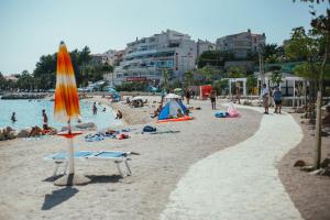 una playa con gente tirada en la arena y una sombrilla en Guesthouse Ante, en Split