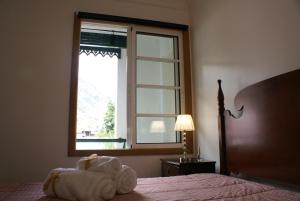 a bedroom with a bed and a large window at Loft Paços da Vila in Ribeira Brava