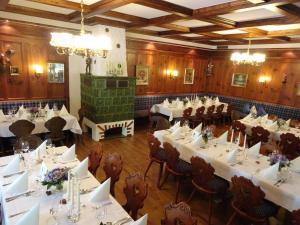 a restaurant with white tables and chairs and a fireplace at Waldcafé Hotel Restaurant in Baden-Baden