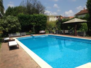 uma grande piscina azul num quintal em Villa Guelfi em Cascina