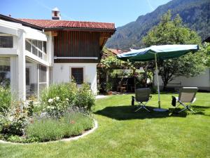 a yard with two chairs and an umbrella at Haus Salzmann in Pfunds