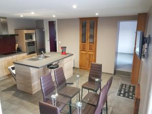 a kitchen with a table and chairs and a counter at Gite de la Combe Ganat 3 étoiles in Sanvignes-les-Mines