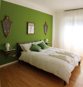 ミラノにあるLuminous stylish quiet 150m2, Tre Torriの緑の壁のベッドルーム1室(大型ベッド1台付)