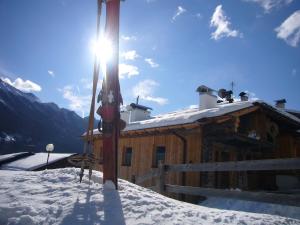 Cabaña cubierta de nieve con esquís en la nieve en Chalet Ory, en Vigo di Fassa