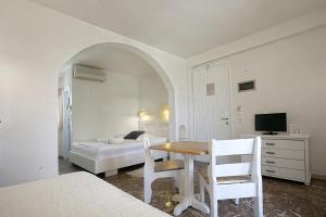um quarto com uma cama, uma mesa e cadeiras em Glaros Studios em Naxos Chora