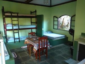 a room with a table and chairs and bunk beds at Ouro Grosso Chales in Iporanga