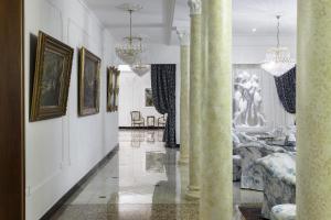 a hallway with columns and paintings on the walls at Grand Hotel Trieste & Victoria in Abano Terme