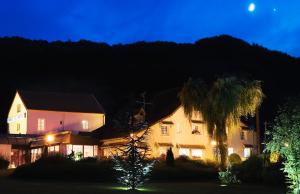 Una casa di notte con la luna nel cielo di auberge le relais a Reuilly-Sauvigny