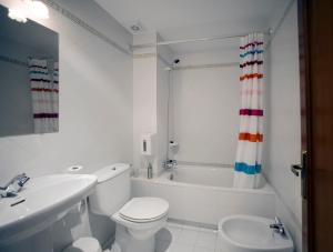 y baño blanco con aseo, bañera y lavamanos. en Casa Rural Maialde, en Elgeta