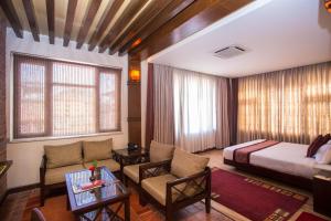 a hotel room with a bed and a couch at Hotel Marshyangdi in Kathmandu