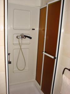 a bathroom with a shower door with a hose at Moravská Bouda in Špindlerův Mlýn