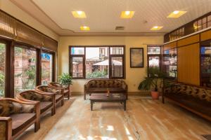a waiting room with couches and a table and windows at Hotel Marshyangdi in Kathmandu
