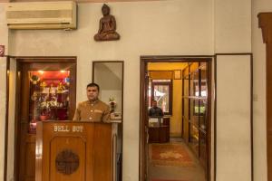 a man standing at the counter of a restaurant at Hotel Marshyangdi in Kathmandu