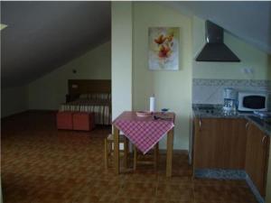 a kitchen with a table with a pink table cloth at Apartamentos María Del Carmen in Torremolinos
