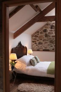 a bedroom with a large bed with two lamps at The Granary in Lifton