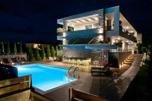 a swimming pool in front of a house at night at Chrysalis studios in Stavros