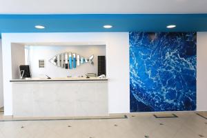 a lobby with a large blue painting on the wall at Blu Acqua Hotel in Agios Nikolaos