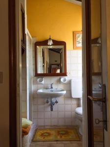 a bathroom with a sink and a toilet and a mirror at Due Piani in Barberino di Val dʼElsa