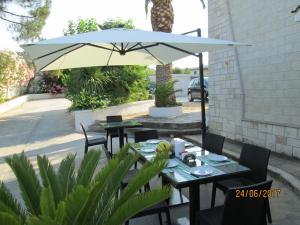 a patio with two tables and an umbrella at Hotel Tropical in Ostuni