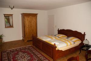 a bedroom with a wooden bed and a wooden cabinet at Villa Sängerstein in Eisenach