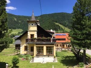 une maison avec une tour et un balcon dans l'établissement Gurkhof Ferienwohnungen, à Gnesau