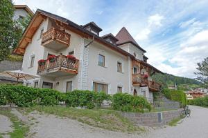 - un grand bâtiment blanc avec des balcons sur le côté dans l'établissement Villa sulla passeggiata, à Ortisei