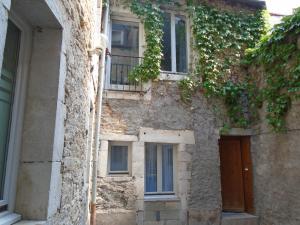 - un vieux bâtiment en pierre avec une porte et des fenêtres dans l'établissement Appartements Baron Bouvier, à Vesoul