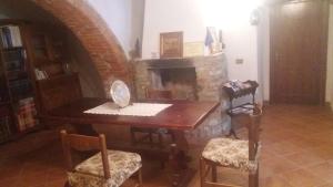 Habitación con mesa, sillas y chimenea de ladrillo. en Azzurre BeB, en Laterina
