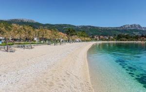a beach with turquoise water and trees at Studio Apartman Šutić in Kastel Novi