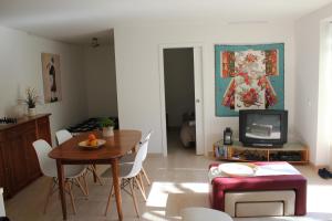 a living room with a table and a tv at Quinta Japonesa in Carvalhal Bemfeito