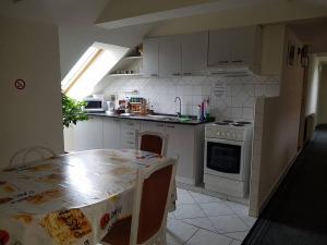 a kitchen with a table and a stove top oven at Penzión KORMOŠ in Štúrovo