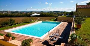 a swimming pool in a backyard with a wooden deck at Podere Casalsole in Certaldo