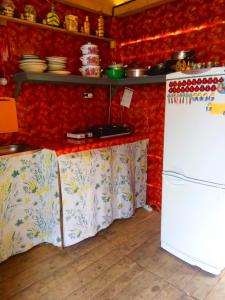 a kitchen with red walls and a white refrigerator at Turbaza Kedroviy bereg in Artybash