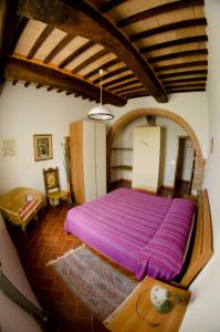 a bedroom with a large purple bed in a room at Podere Remignoli in San Gimignano