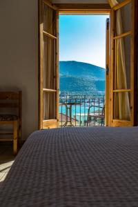 a bedroom with a bed and a view of the ocean at Maroudas Stavros Apartments in Vathi
