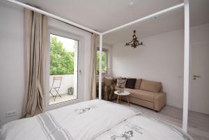 ein Schlafzimmer mit einem Bett, einem Sofa und einem Fenster in der Unterkunft Ferienwohnung Zweisamkeit in Bad Harzburg