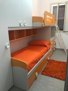 - une chambre avec 2 lits superposés et des draps orange dans l'établissement Casa Àbola, à Avola