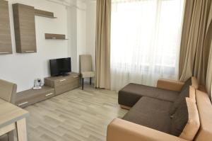 a living room with a couch and a television at Summerland Happy Blue Apartments in Mamaia