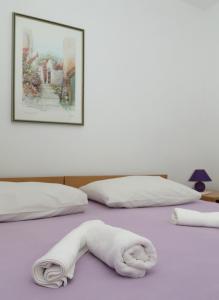 a white towel laying on top of a bed at Marija Rooms in Dubrovnik