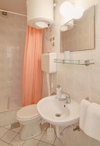 a bathroom with a white toilet and a sink at Marija Rooms in Dubrovnik
