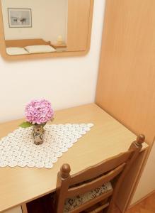 a vase of flowers on a table with a mirror at Marija Rooms in Dubrovnik