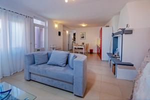 ein Wohnzimmer mit einem blauen Sofa und einem Tisch in der Unterkunft Dietro la grotta in Rovinj