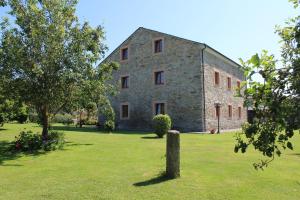 a large stone building with trees in a field at Apartamentos Casa Cerolleiro in Castropol