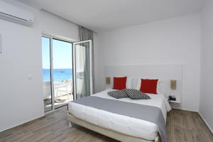 a bedroom with a bed with a view of the ocean at Blu Acqua Hotel in Agios Nikolaos