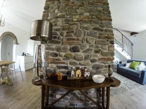 una sala de estar con una pared de piedra y una mesa. en Villa Il Cipresso, en Terranuova Bracciolini