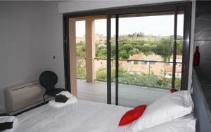 a bedroom with a bed and a large window at Appartement Le Saint Nazaire - Les Balcons de la Cité in Carcassonne